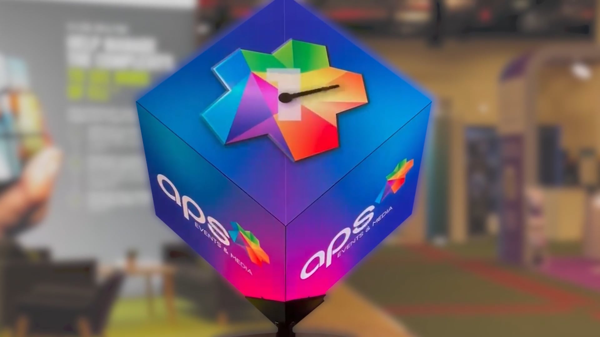 A large LED cube with the aps logo presented on it.